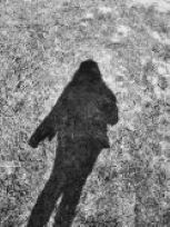 a black and white shadow outline of a person on the grass